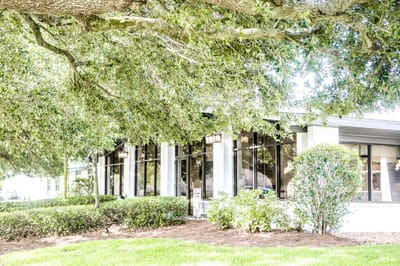 Exterior view of the facility under large trees