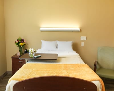 A cozy resident room with a bed and flowers