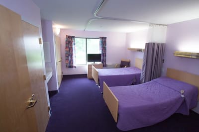 A shared resident room with twin beds and a TV.