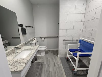 Accessible bathroom with grab bars and specialized seating