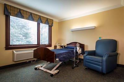 Private resident room with a bed and chair