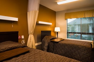 Cozy resident room with twin beds and curtains