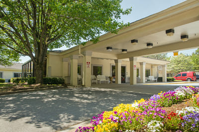 Exterior view of the facility with flowers and trees