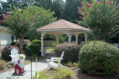A peaceful gazebo surrounded by garden shrubs and flowers