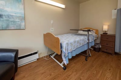 Cozy resident room with a hospital bed and artwork