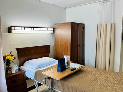 A bright and tidy resident room with a bedside table