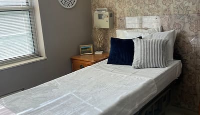 A well-decorated private resident room with bedding and artwork
