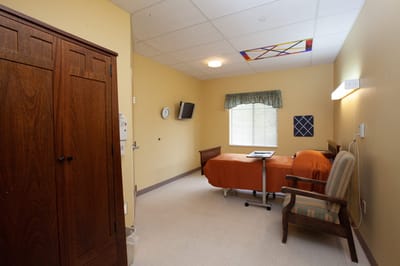 Interior view of a resident room with a bed and wardrobe