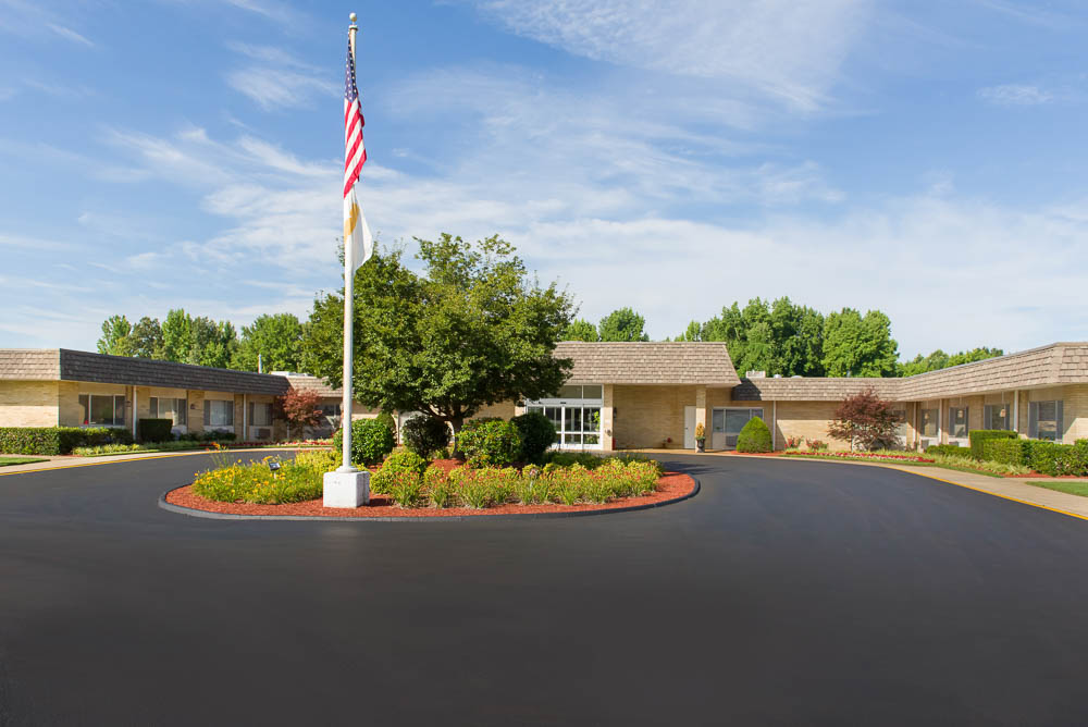 Exterior view of the facility with gardens and flag