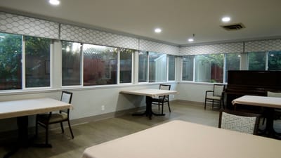 Bright common area with tables and piano