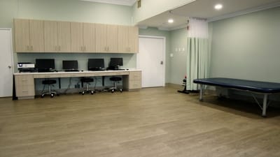 A well-equipped therapy room with computers and treatment table