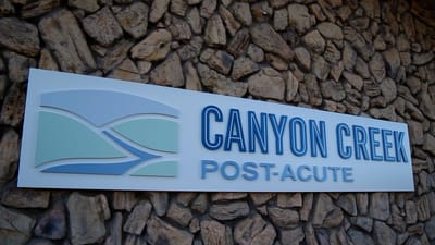 Canyon Creek Post-Acute facility logo on a stone wall