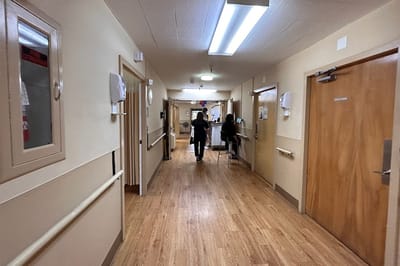 Staff member assisting a resident in a hallway