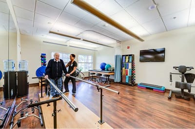 Therapist assisting a resident in a rehabilitation room