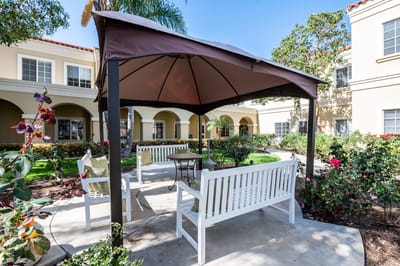 Outdoor seating area under a gazebo in a garden