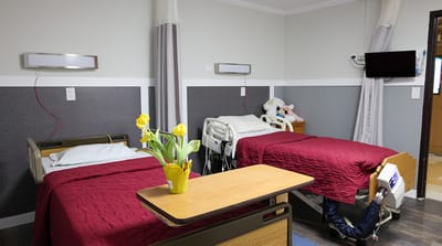 Two hospital beds in a shared resident room.