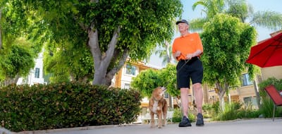 Resident walking a dog in a garden area