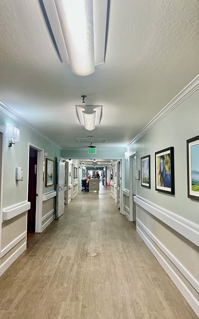 Well-lit interior hallway with artwork on the walls.