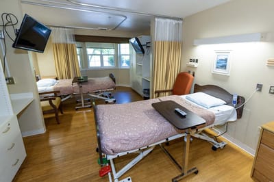 A well-furnished resident room with adjustable bed.