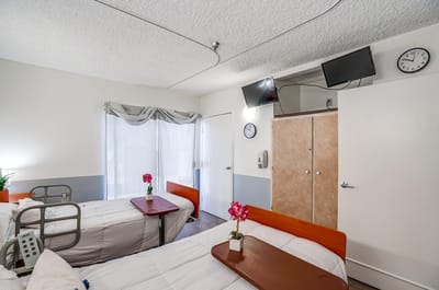 Bright resident room with two beds and decor