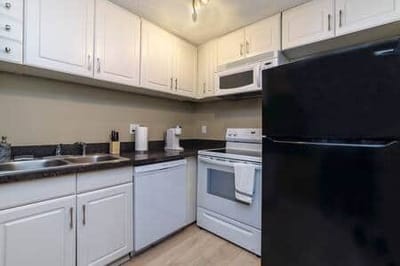 Clean kitchen area with white cabinets and appliances.