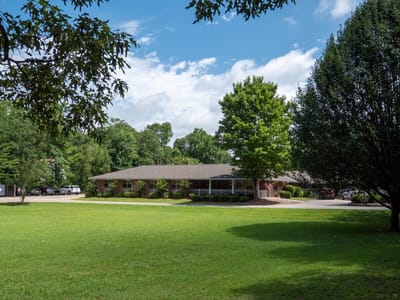 Exterior view of Brown Nursing Home surrounded by greenery.