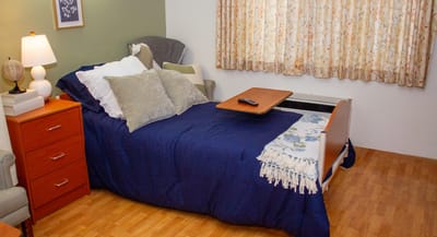 Cozy private resident room with a bed and chair