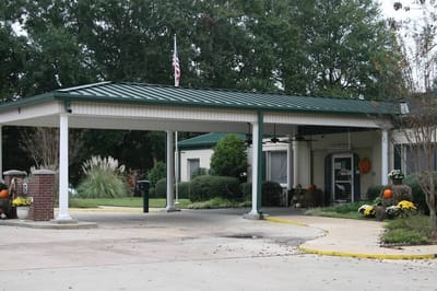 Front entrance with covered awning and autumn decorations.