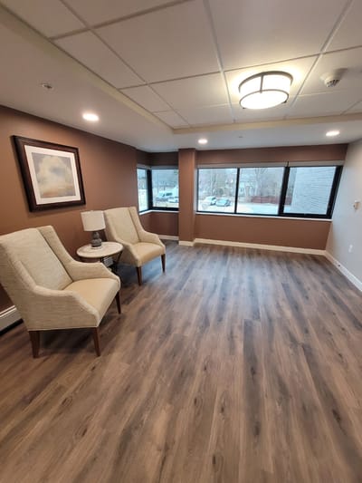 Common area with two chairs and large windows
