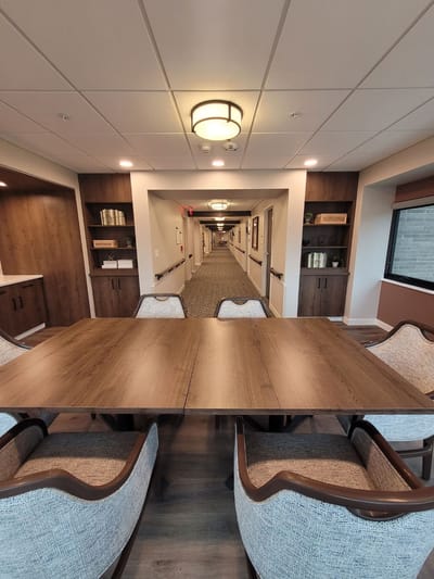 Common area with a table and chairs in a hallway.