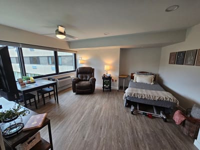 Cozy resident room with a chair and bed.
