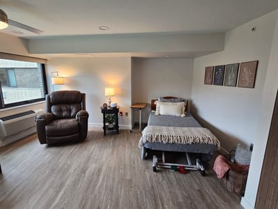 Comfortable resident room with a bed and chair.