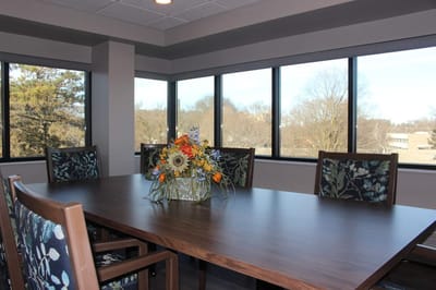 A dining area with a table and flowers.