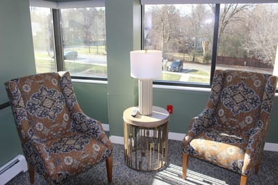 Cozy lounge area with patterned chairs and a lamp