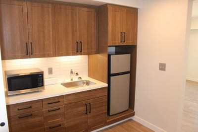 Modern kitchenette with appliances and cabinetry.
