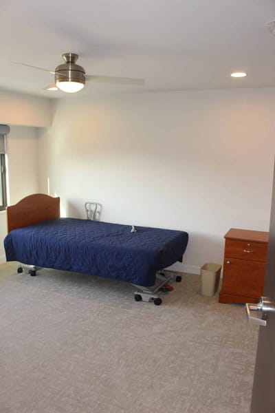 A simple resident room with a bed and furniture.