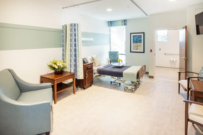 A warmly decorated resident room with furniture and flowers