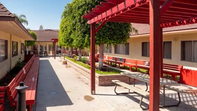 Outdoor seating area with red benches and greenery
