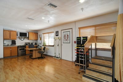 An activity room with exercise equipment and kitchen area