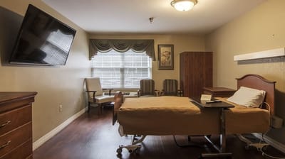 A private resident room with a bed and seating area