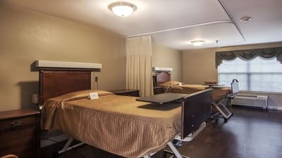 A private resident room with two beds and basic furnishings