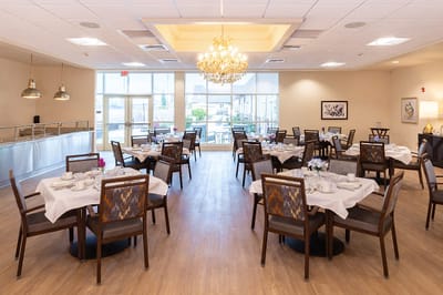 Bright dining room with tables set for residents