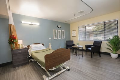 Well-furnished private resident room with bedside table