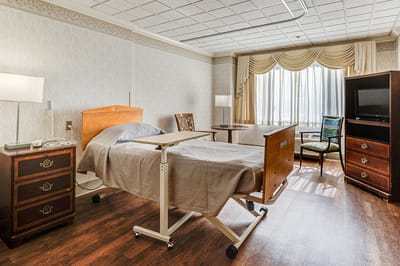 A well-furnished private resident room with a bed and seating area
