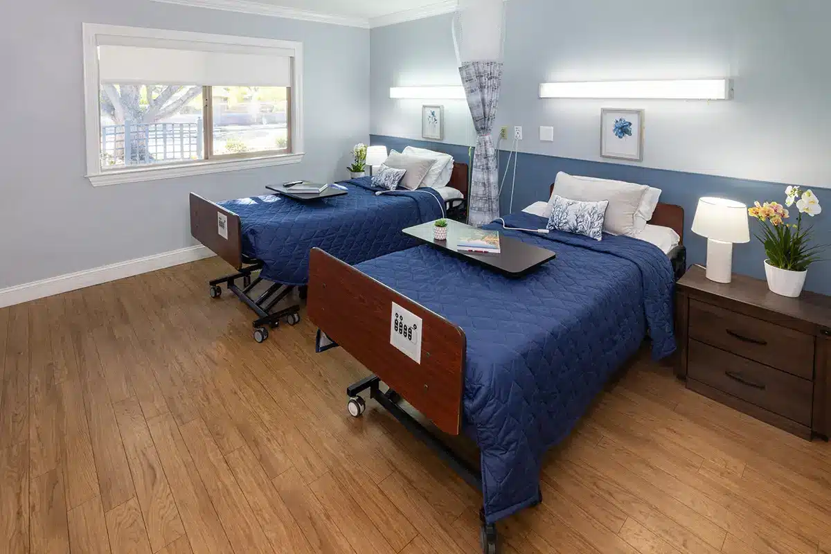 A well-furnished resident room with two beds and decor