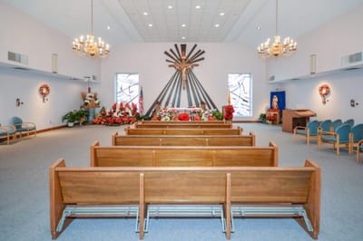 Interior view of a chapel with pews and floral decorations