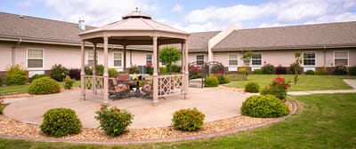 Outdoor gazebo area surrounded by gardens