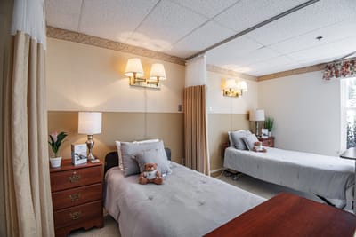 Comfortable resident room with two beds and warm lighting