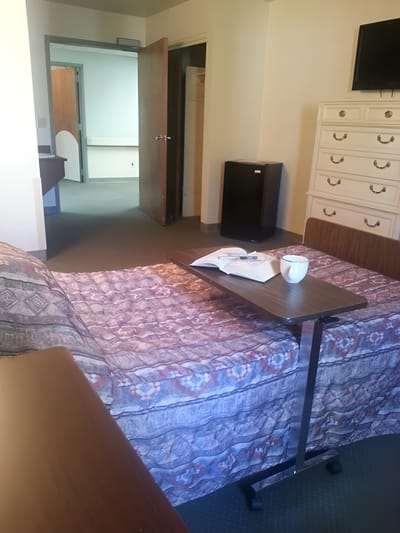 A private resident room with bed and table setup