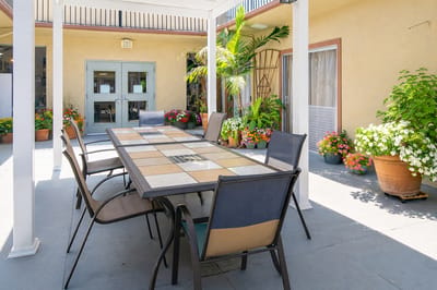 Outdoor seating area with a large table and flowers